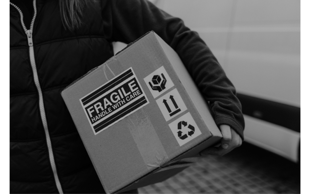 woman carrying cardboard box containing fragile items
