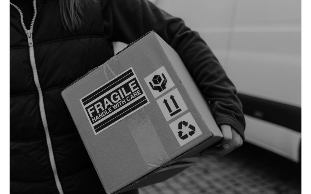 woman carrying cardboard box containing fragile items